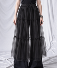 Black gauze overlay skirt close-up showing three sheer tiers, gathered seams and elastic waistband.