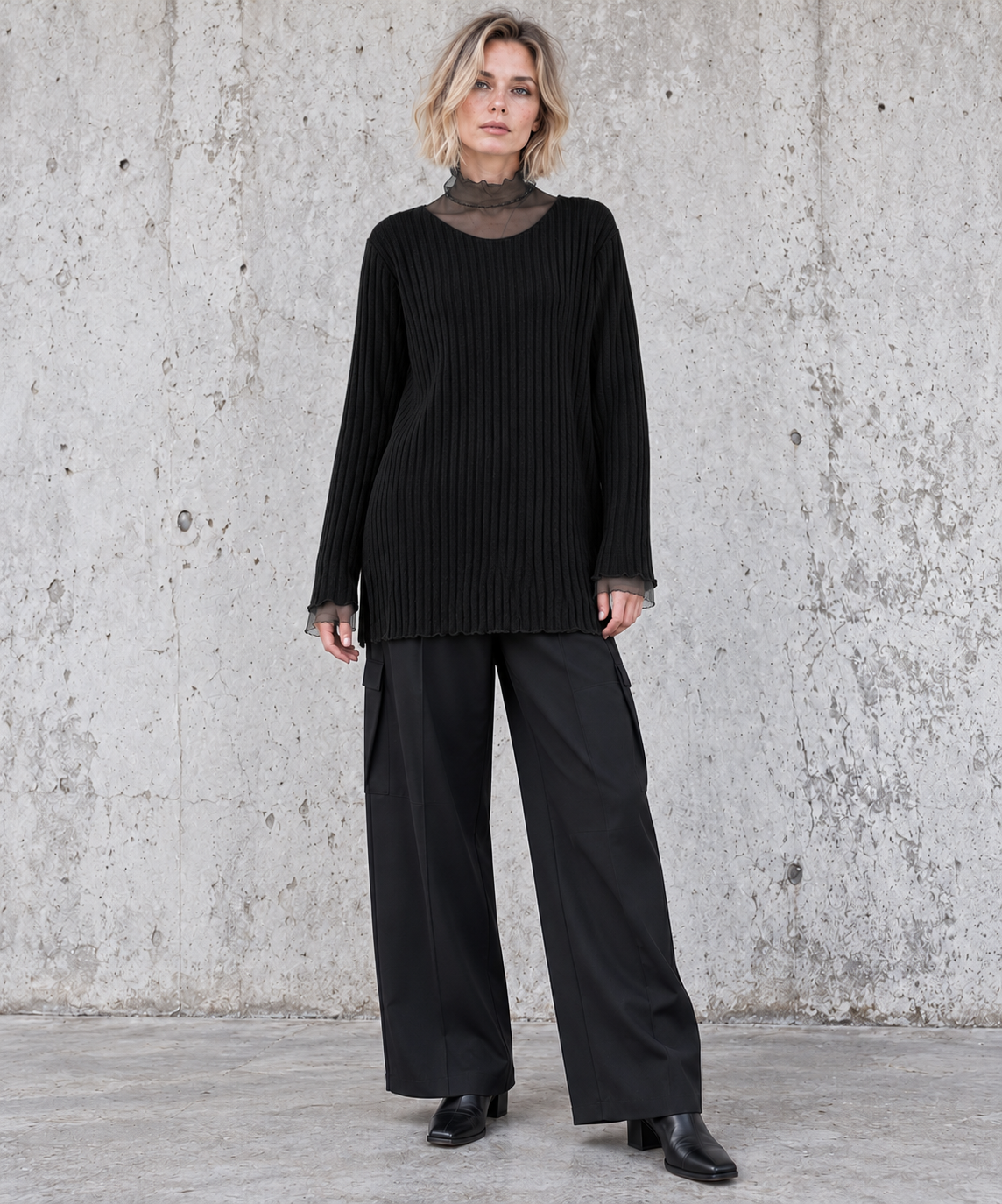 Front view of black oversized rib-knit sweater with sheer mesh collar and cuffs on a blonde model – Simple Moderne
