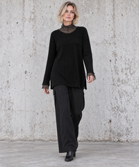 Blonde model walking in black oversized rib-knit sweater and wide-leg black trousers – Simple Moderne