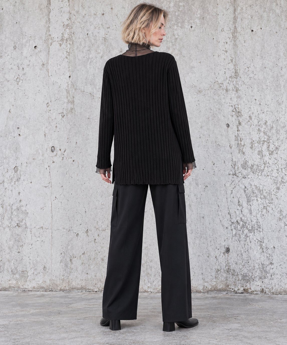 Back view of black oversized rib-knit sweater with sheer mesh collar and relaxed longline fit – Simple Moderne