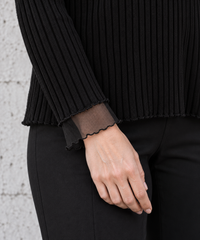 Detail of black rib-knit sleeve with sheer mesh cuff and waved lettuce edge – Simple Moderne