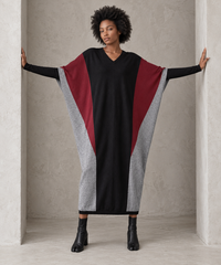 Full-length front view of the black oversized block knit midi dress with arms extended, showing its generous width and tapered hem.