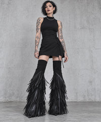 Black vegan leather tassel flare leg warmers on a tattooed gothic model, full-length front view styled with a short black skirt.
