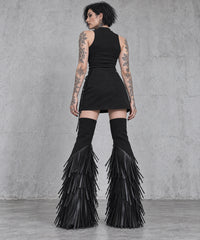 Back view of black vegan leather tassel flare leg warmers styled with a short black skirt.