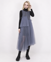 Blue-violet mesh asymmetric layered midi dress on a blonde model, three-quarter view with one hand at her hair.