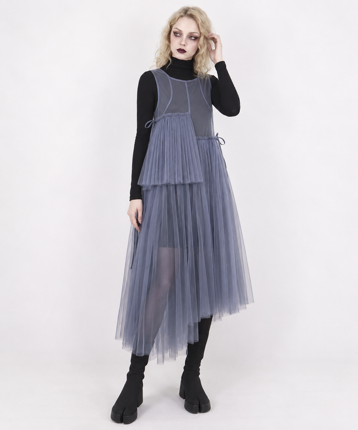 Blue-violet mesh asymmetric layered midi dress on a blonde model, three-quarter view with one hand at her hair.