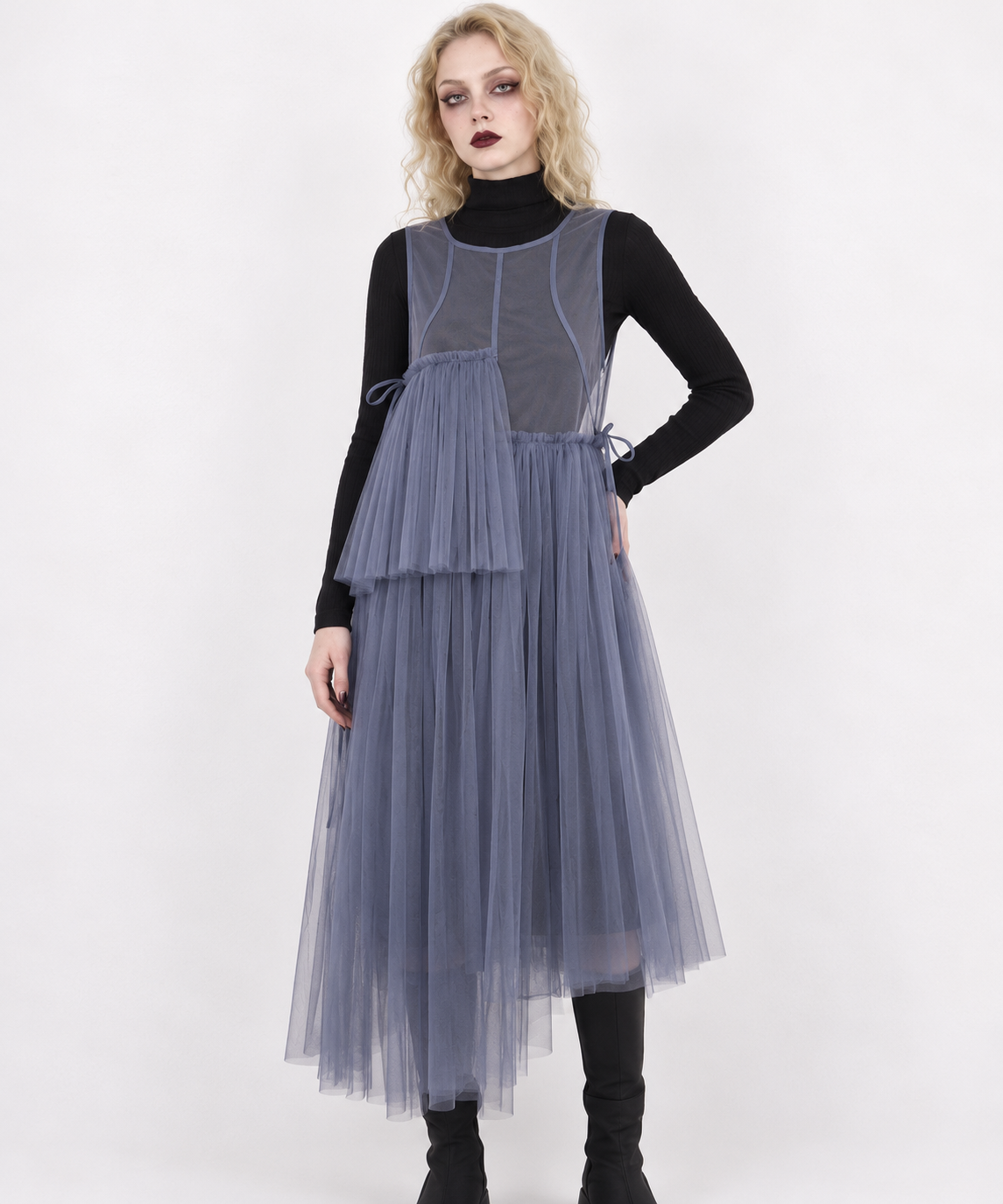 Closer model view of the blue-violet mesh dress, showing the bound neckline, curved seams and asymmetric pleated panels.