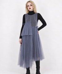 Closer model view of the blue-violet mesh dress, showing the bound neckline, curved seams and asymmetric pleated panels.