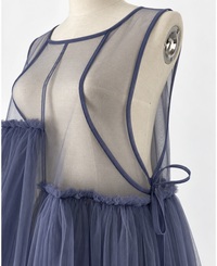 Blue-violet mesh dress on a cream mannequin, close-up of the sheer bodice, neckline binding, curved seams and side bow.