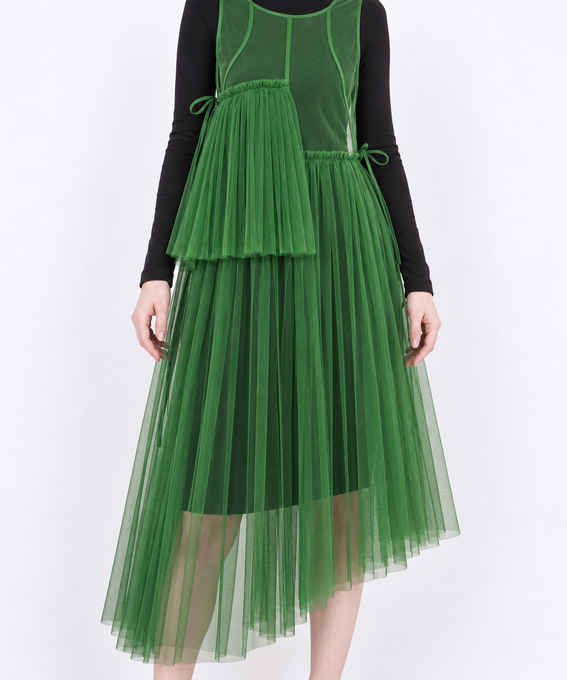 Green mesh dress skirt detail showing fine pleats, side ties, sheer fabric and the asymmetric hem.