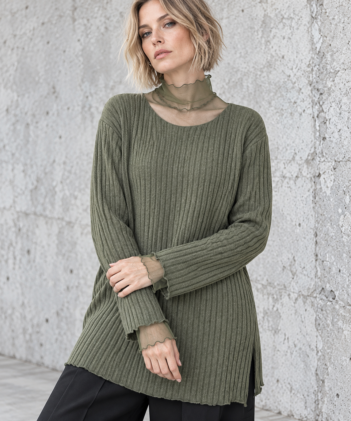 Olive Green Oversized Turtleneck Knit Sweater. Closer view of the olive rib-knit sweater showing sheer mesh cuff extensions and delicate waved edges.