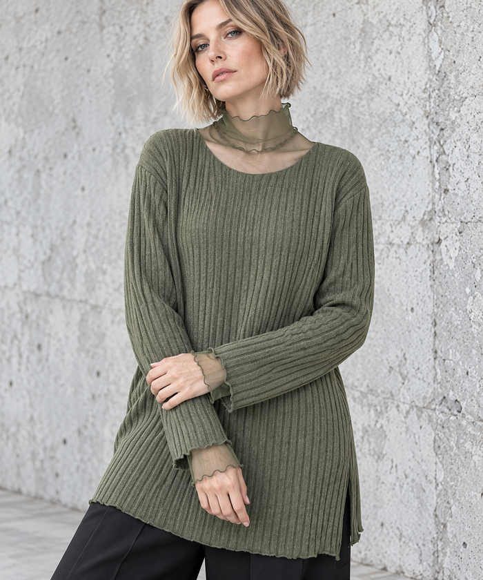 Olive Green Oversized Turtleneck Knit Sweater. Closer view of the olive rib-knit sweater showing sheer mesh cuff extensions and delicate waved edges.