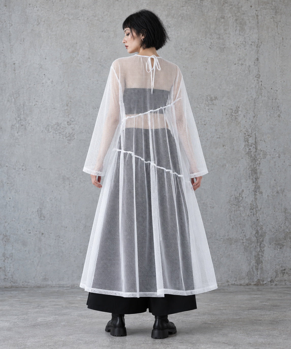 Back view of the white layered gauze maxi dress showing the tie neckline opening and diagonal tier seams.